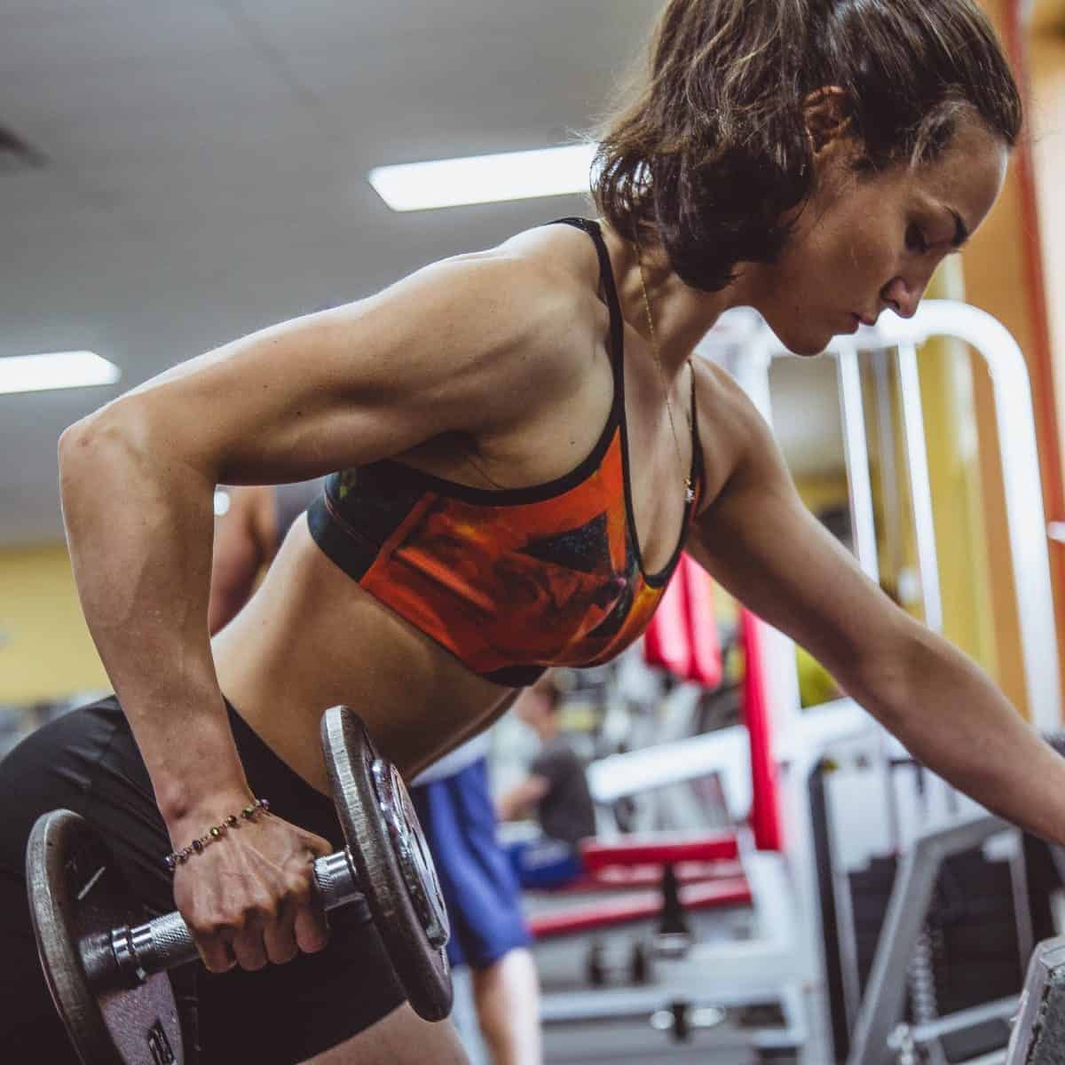 Woman doing single arm bent-over rows on her weaker side at the gym