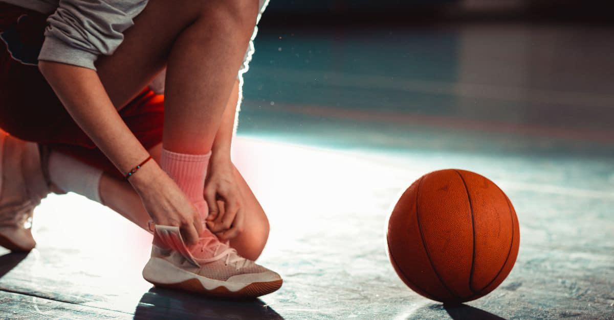 Athlete holding an ankle after a sprained ankle injury