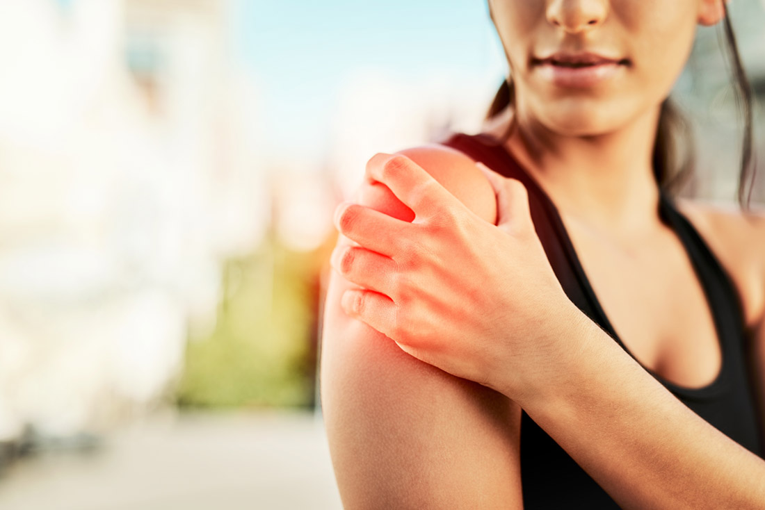 Woman holding her shoulder because of pain