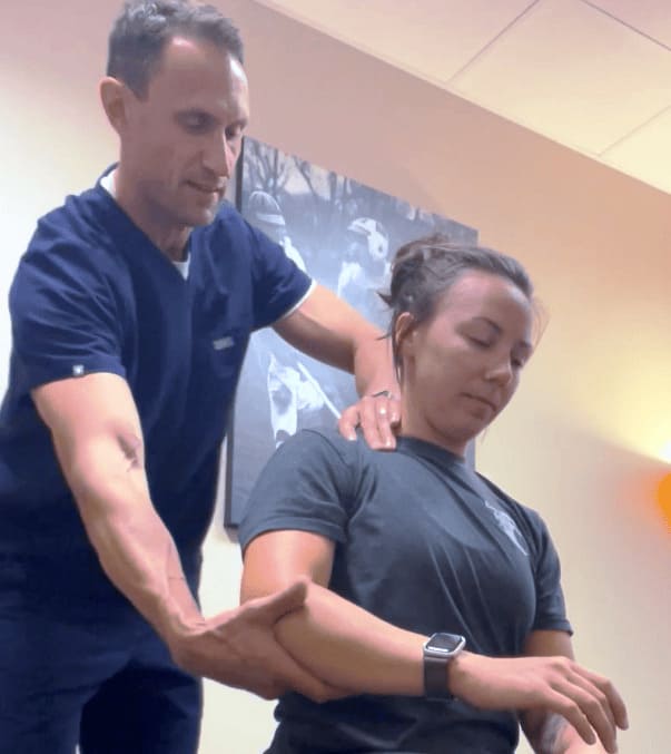 Chiropractor Daniel Holland at True Sport Care and Chiropractic in Smithtown is performing an ART technique helping an athlete with shoulder pain